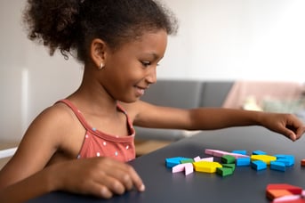 side-view-smiley-girl-making-puzzle
