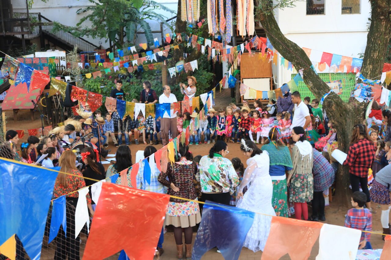 Pessoas dançam em roda na Festa Junina da Educação Infantil da Escola Viva em 2019